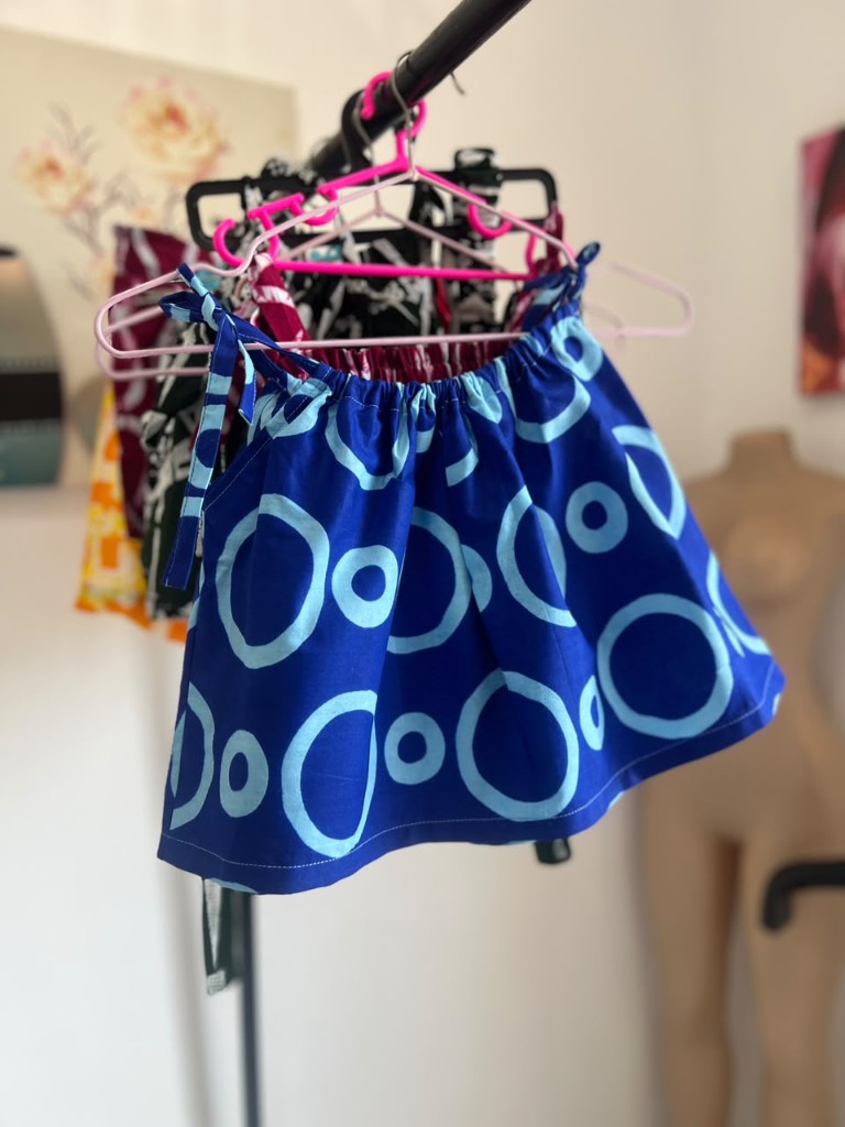 The same indigo top, the print opening across the skirt of the cloth.