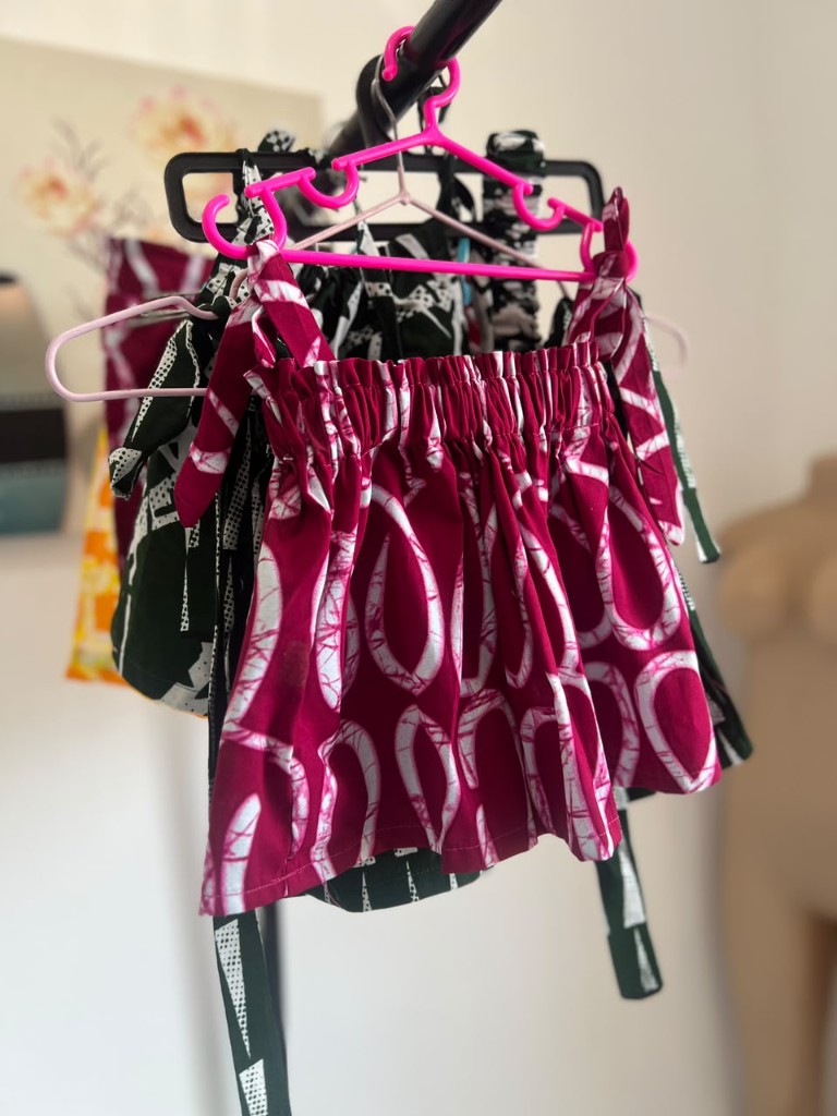 The magenta top among other printed pieces on the atelier rail.